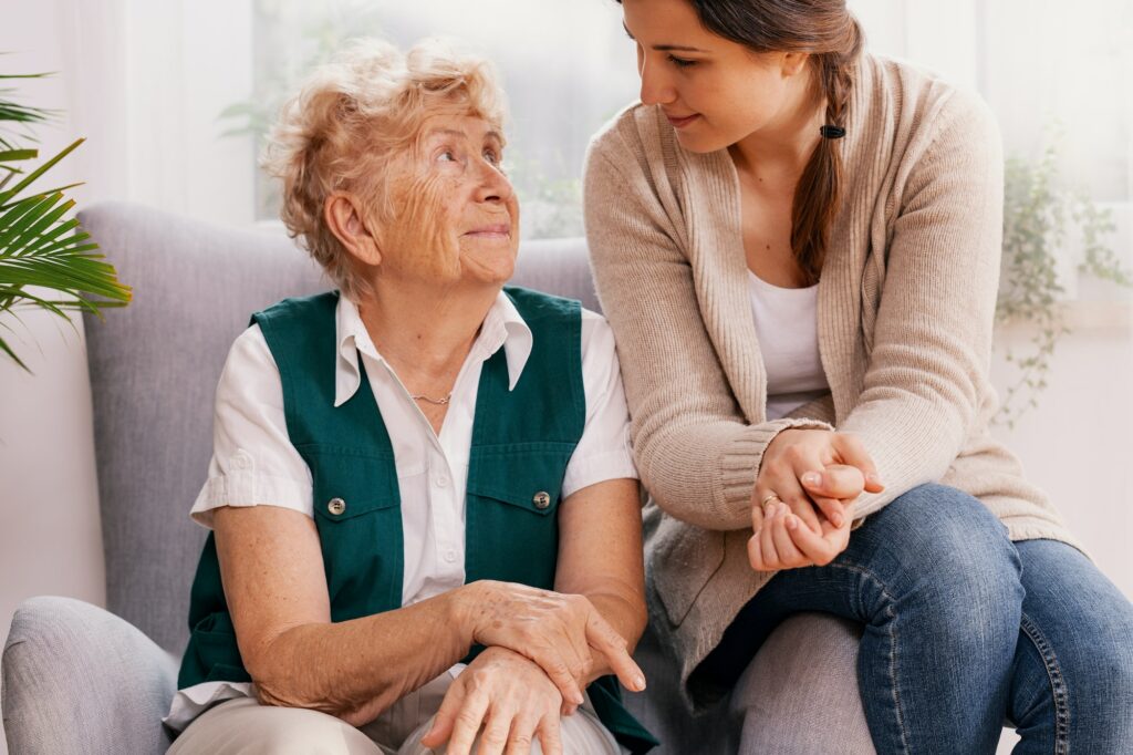 Grandmother with granddaughter seating on armchair